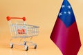 Empty metal Shopping basket and Samoan Flag on colored background consumer basket