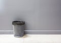 An empty metal trashcan (bin) isolated on gray