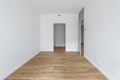 Empty minimalist modern room with white walls, opened grey door and oak wood floor.