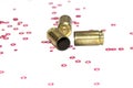 Empty 9mm bullet shells over white background with red hexagon small objects Royalty Free Stock Photo
