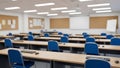 Empty modern classroom with blue chairs, wooden desks, keyboards, and mice, ready for education and learning Royalty Free Stock Photo
