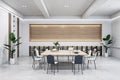 An empty modern conference room with a large table, chairs, and shelving units, lit by overhead lights on a white and wood Royalty Free Stock Photo