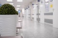 Empty modern hospital corridor, clinic hallway interior background with white chairs for patients waiting for doctor visit. Royalty Free Stock Photo