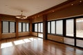 Empty modern living room interior with large windows, wooden floors, and recessed lighting Royalty Free Stock Photo