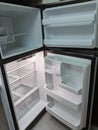 Empty, modern refrigerator and freezer with opened doors. Inside of a clean fridge with plastic shelves Royalty Free Stock Photo