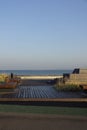 Empty modern wooden bench on the Reidi promenade (estonian Reidi tee) on the shore of Baltic sea. Cloudy summer day