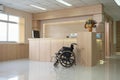 Empty modern wooden reception counter with monitor and wheelchair in the hospital