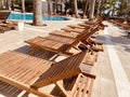 Empty modern wooden sunbeds by turquoise swimming pool. cyprus. empty hotel in quarantine period before opening Royalty Free Stock Photo