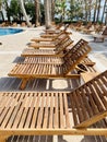 Empty modern wooden sunbeds by turquoise swimming pool. cyprus. empty hotel in quarantine period before opening Royalty Free Stock Photo