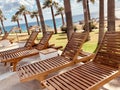 Empty modern wooden sunbeds by turquoise swimming pool. cyprus. empty hotel in quarantine period before opening Royalty Free Stock Photo