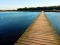 Empty mole on blue lake, wharf for hired boats in marina. Ready for trip ships. Royalty Free Stock Photo