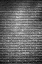 Empty monochrome brick wall background texture with spot light in the middle.