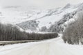 Empty mountain asphalt road in winter covered with snow on a cloudy day. The concept of driving a car in winter ice and Royalty Free Stock Photo