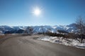 Empty mountain road on Alps with curve in a sunny day Royalty Free Stock Photo