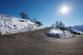 Empty mountain road curve on Alps with snow on sides, blue sky Royalty Free Stock Photo