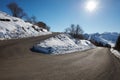 Empty mountain road curve with snow on sides, blue sky Royalty Free Stock Photo