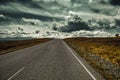 Empty mountain road goes into the distance beyond the horizon where the clouds are gathering. Royalty Free Stock Photo