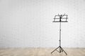 Empty music note stand near brick wall indoors Royalty Free Stock Photo