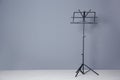 Empty music note stand near grey wall indoors. Royalty Free Stock Photo