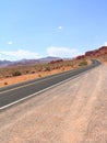 Empty Nevada highway disappearing into the background with mountains