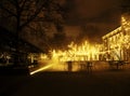 Empty night restaurant, lot of tables and chairs with noone, magic fairy lights on trees like christmas celebration Royalty Free Stock Photo