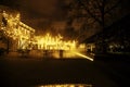 Empty night restaurant, lot of tables and chairs with noone, magic fairy lights on trees like christmas celebration Royalty Free Stock Photo