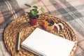 Empty note and pen laying on round natural napkin with small pilea flower and dry coconut and apricot