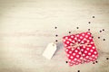 Empty note tied over a red dotted gift box. Wooden background. Vintage style. Royalty Free Stock Photo
