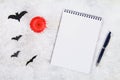 Empty notebook, blood candle, pen and bats on a light table. The concept for Halloween. Royalty Free Stock Photo