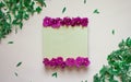 Empty notebook decorated purple flowers on a white background, top view. Notepad decorated with green leaves and violet. Flat lay.