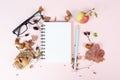 Empty notebook with eyeglasses, an apple and a hedgehog, autumn template with colorful leaves, office desk, pastel color