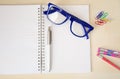 Empty notebook with office accessories and blue frame eye glasses Royalty Free Stock Photo