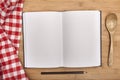 Empty notebook for recipes with spoon on wooden Royalty Free Stock Photo