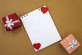 An empty notebook with two red hearts on a yellow background among two gift boxes. Festive background. Greeting Card Royalty Free Stock Photo