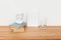 Empty notebook on wooden table with books and small David plaster copy made in China bust sculpture. Minimal work space Royalty Free Stock Photo