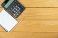 Empty notepad and calculator and pencil on wooden desk, copy space, top view background Royalty Free Stock Photo