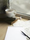 Empty notepad, coffee cup and books on windowsill.