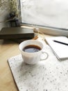 Empty notepad, coffee cup and books on windowsill