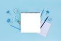 Empty notepad template with office supplies on a blue pastel background