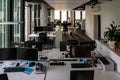 Empty office room with multiple work desks computers and supplies left behind by workers during pandemic lock down