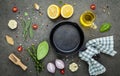 Empty old cast iron skillet on dark stone background. Ingredients for making steak  concept with copy space . Various herbs and Royalty Free Stock Photo