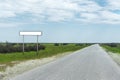 Empty old road sign for the name of a city or village populated area near the road in the countryside against a blue sky Royalty Free Stock Photo