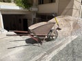 An empty old rusty hand wheelbarrow and shovel next to the pile of sand. Royalty Free Stock Photo