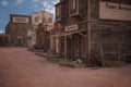 Empty old wild west town street with timber merchant, undertaker, general store and hardeware supplies businesses. 3D rendering Royalty Free Stock Photo