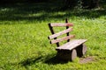 Empty old wooden bench on a green lawn. Sunny day, garden or par Royalty Free Stock Photo