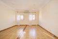 Empty one-story room with two windows with white curtains and light brown tile floors Royalty Free Stock Photo