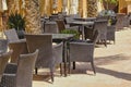 Empty open-air street cafe with rattan armchairs and tables Royalty Free Stock Photo