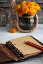 Empty open craft notebook and orange chrysanthemum