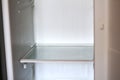 Empty open fridge with shelves, refrigerator. Inside of an empty white fridge. Out of focus Royalty Free Stock Photo