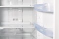 Empty open fridge with shelves, white refrigerator background. Royalty Free Stock Photo